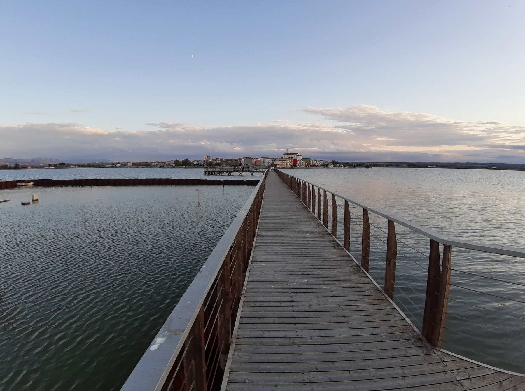 Pontile sul Lago di Lesina con il borgo in fondo alla passerella